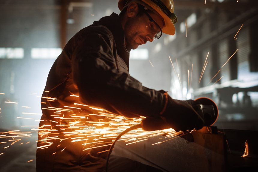 2463672 heavy industry engineering factory interior with industrial worker using angle grinder and c