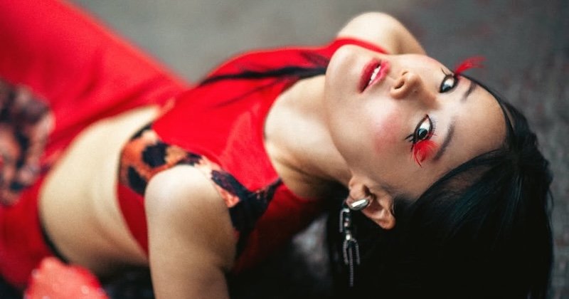 Gigi Lee − Money Money Come To Me press photo wearing a red outfit cropped